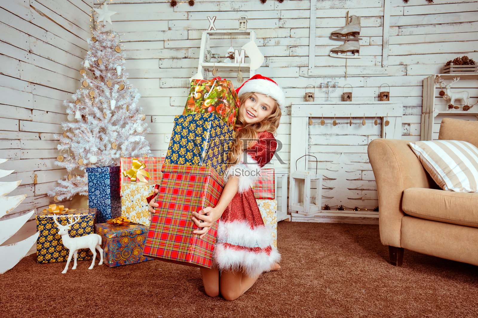 特写肖像惊讶年轻美丽兴奋快乐的女人穿着红色的圣诞老人帽服装，看着被许多礼物孤立的圣诞装饰房间背景震惊照片摄影图片