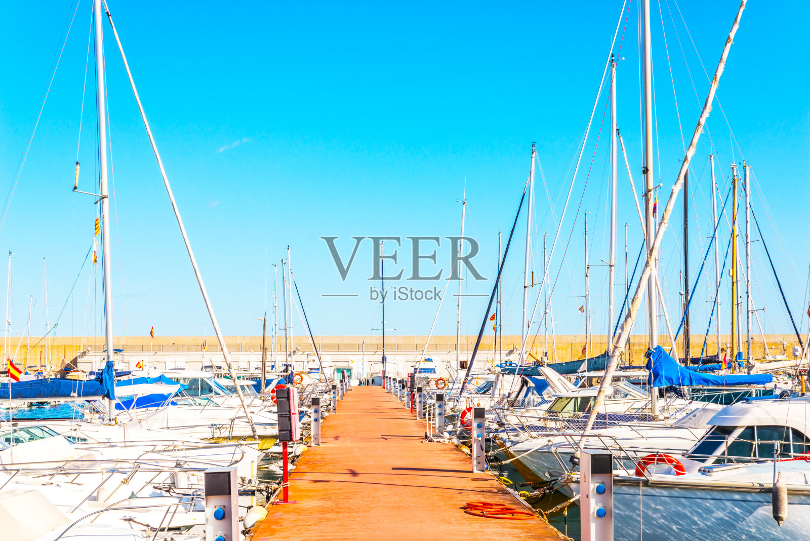 美丽的豪华游艇和摩托艇停泊在港口，炎热的夏日和蓝色的海水在码头，蓝色的天空照片摄影图片