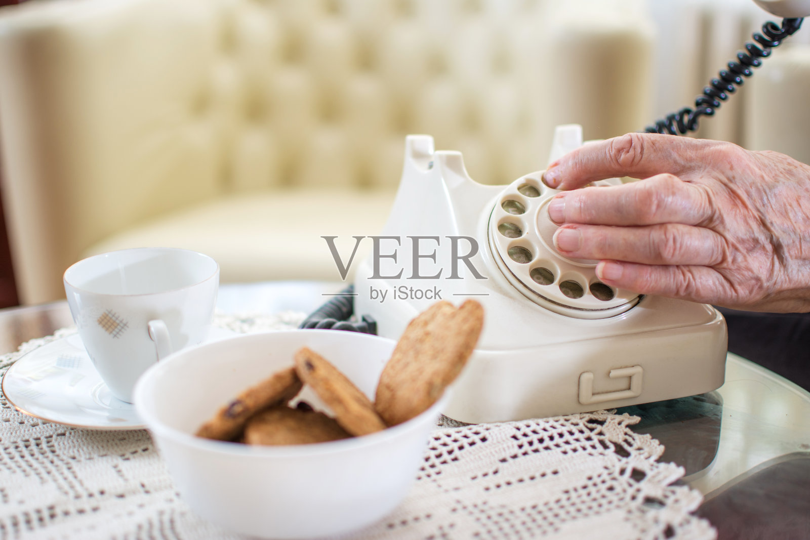 特写的年长妇女的手拨电话号码在复古座机在家里。照片摄影图片