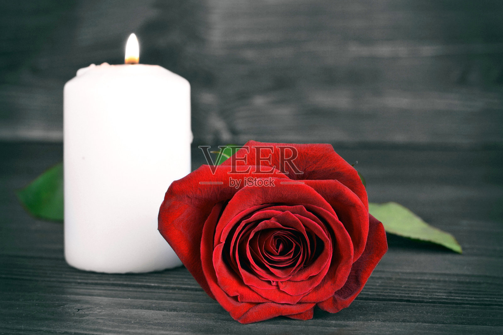 木制背景上点缀着纪念蜡烛和玫瑰照片摄影图片