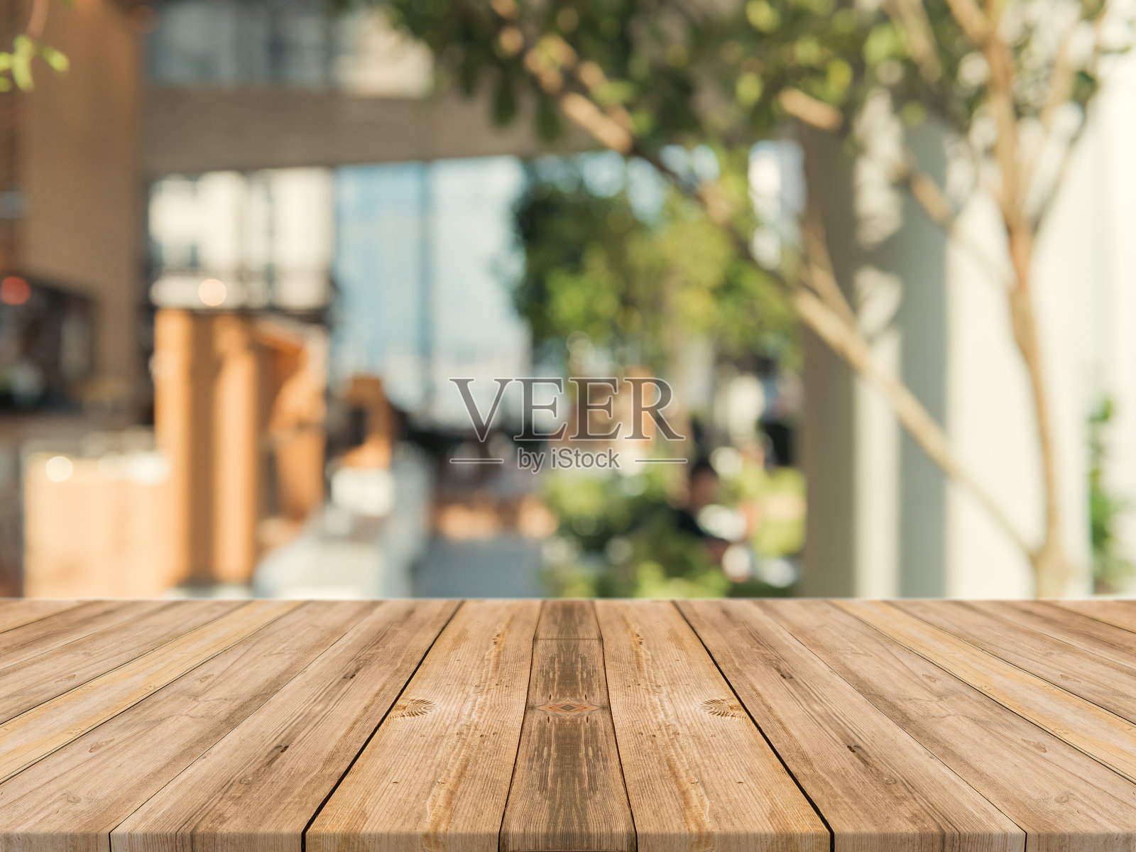 木板空桌面上模糊的背景。透视棕色木桌在咖啡店背景模糊-可以用来模拟蒙太奇产品展示或设计关键视觉布局。照片摄影图片