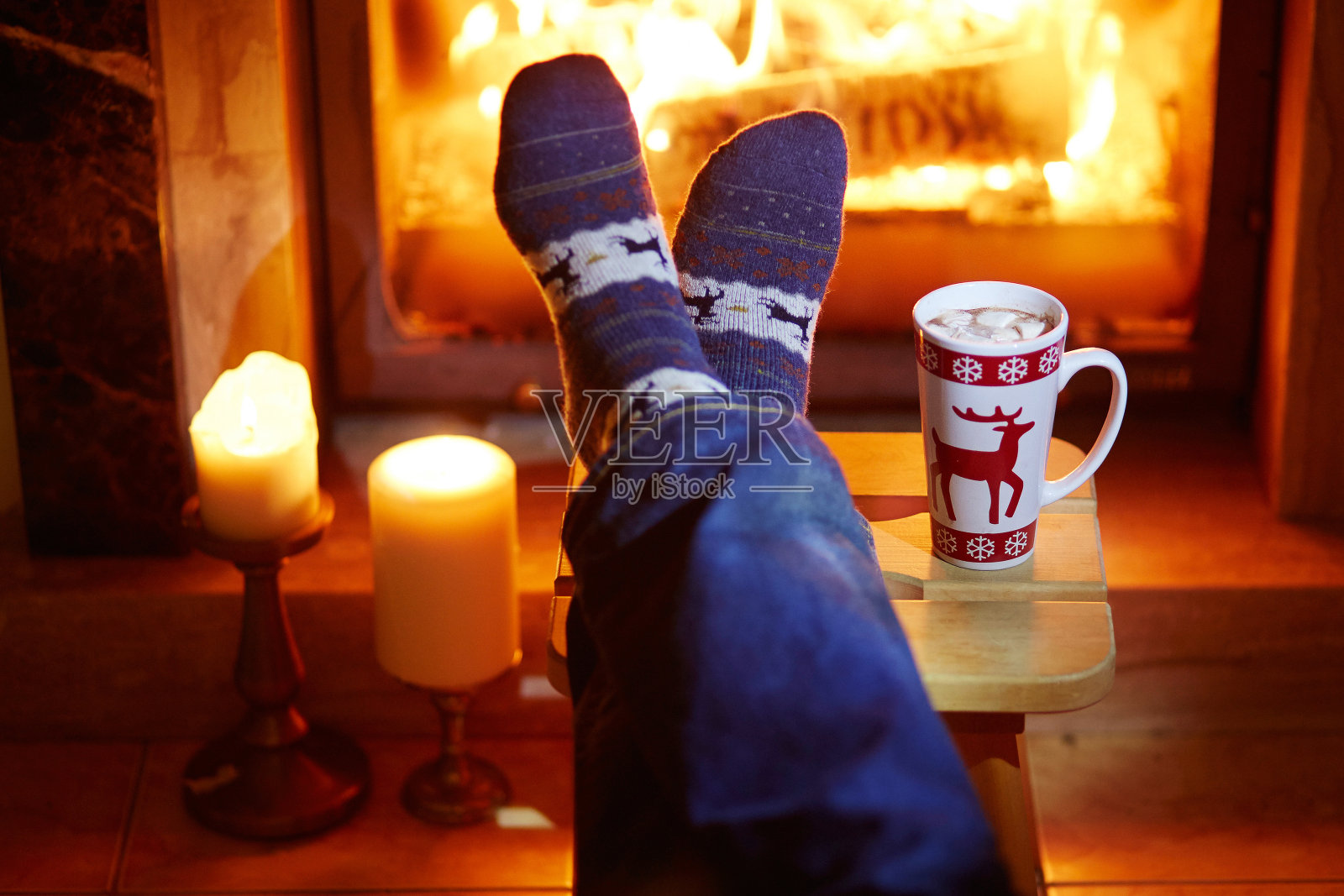 男人的脚在温暖的袜子靠近壁炉照片摄影图片
