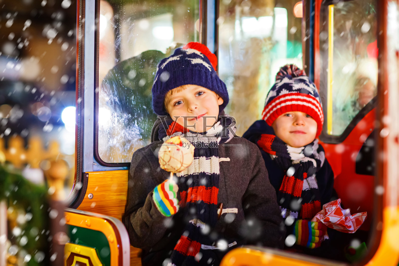 两个小男孩在圣诞市场的旋转木马上照片摄影图片