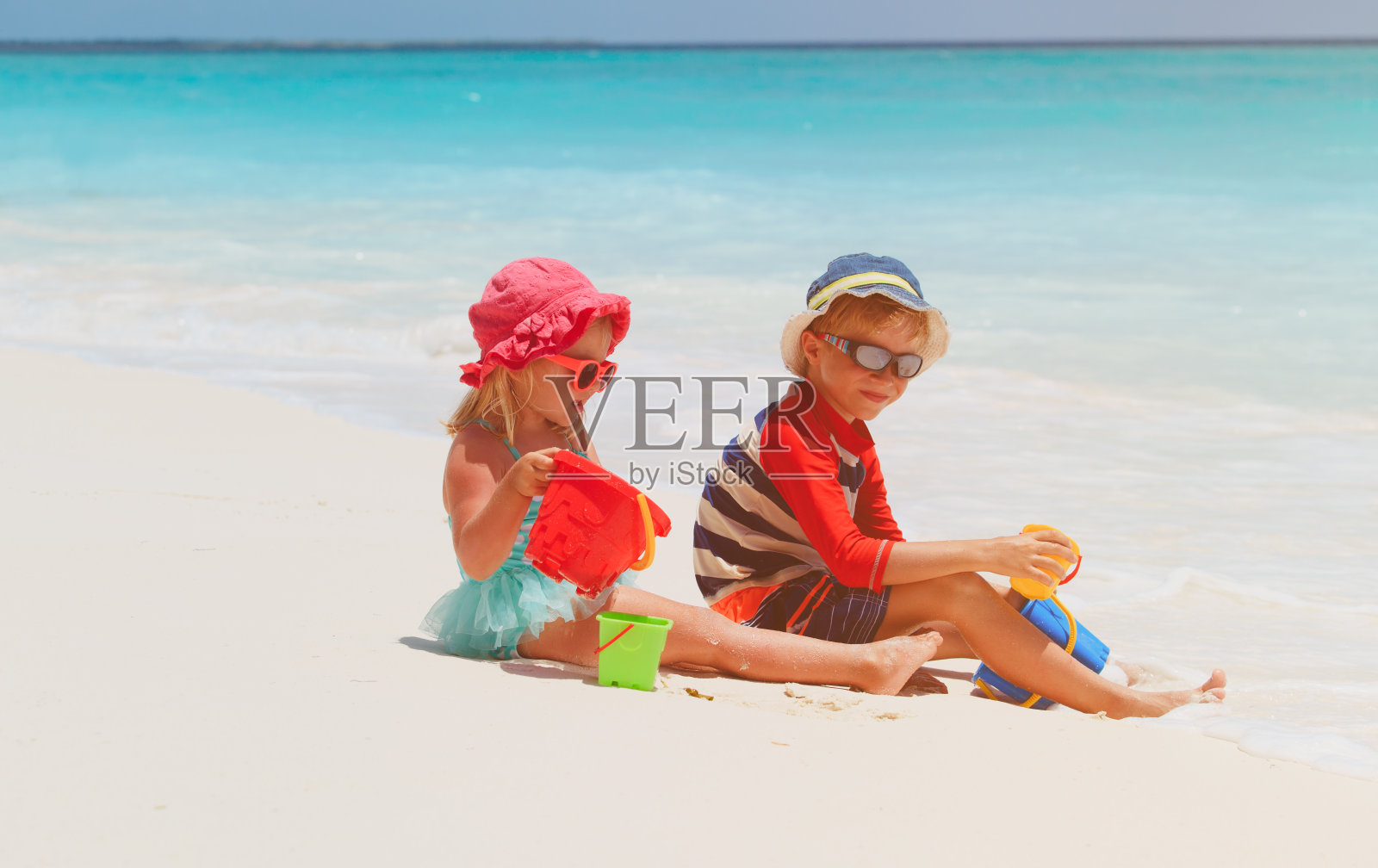小男孩和小女孩在海滩上玩沙子照片摄影图片