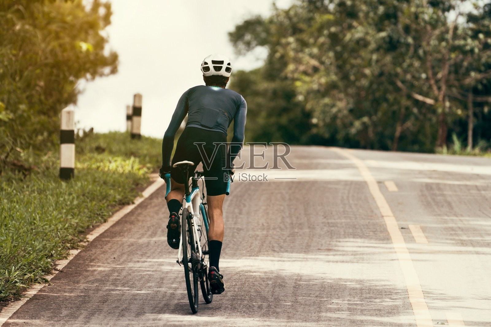骑自行车的人骑着自行车，向山顶爬去。照片摄影图片