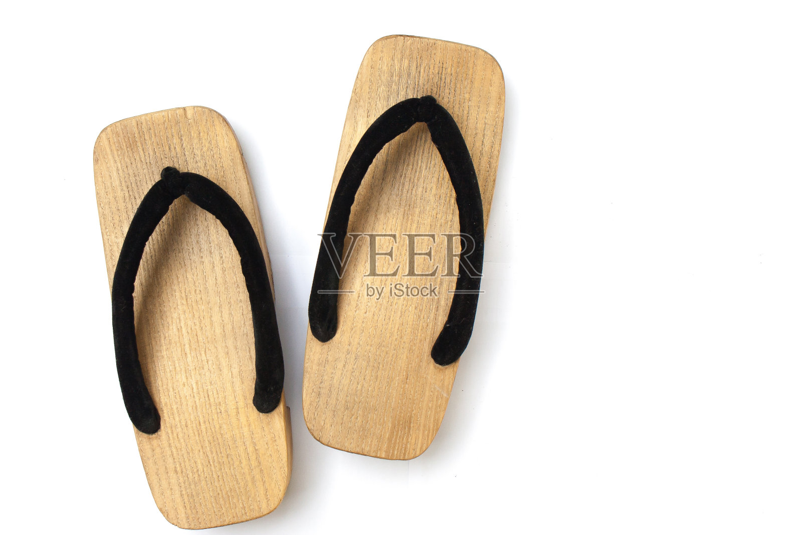 旧木制日本凉鞋孤立在白色的背景。这是一种类似木屐和人字拖的日本传统鞋类。照片摄影图片