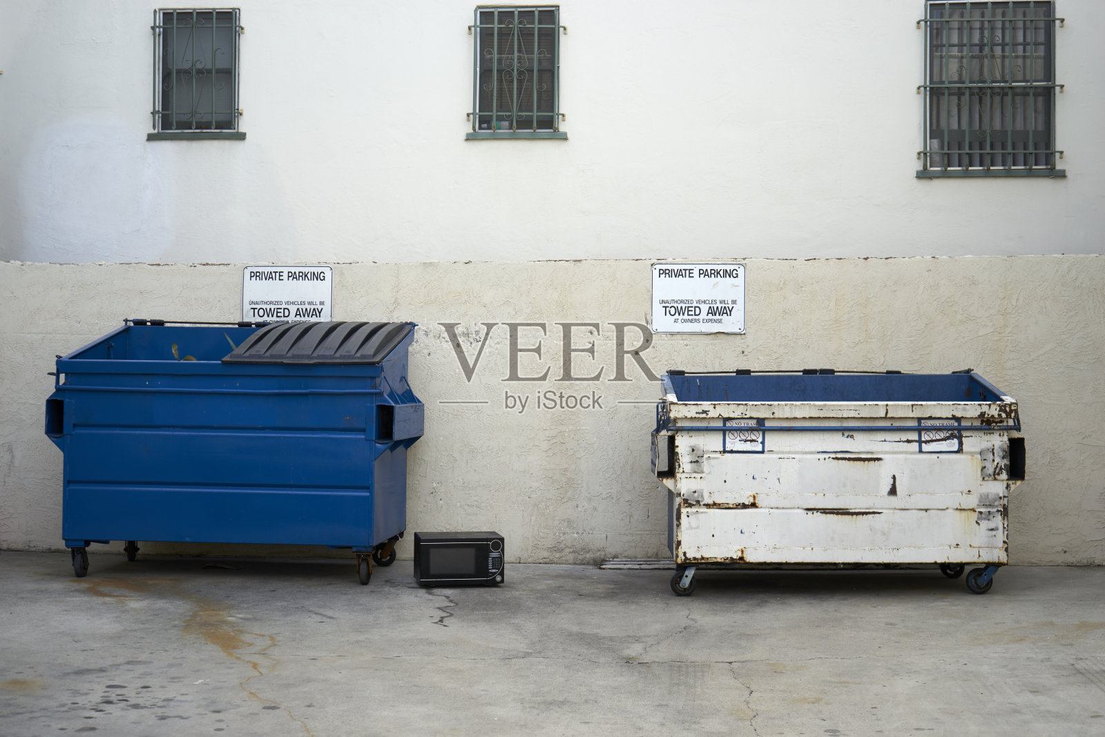 小巷里的蓝色垃圾桶和白色垃圾桶照片摄影图片