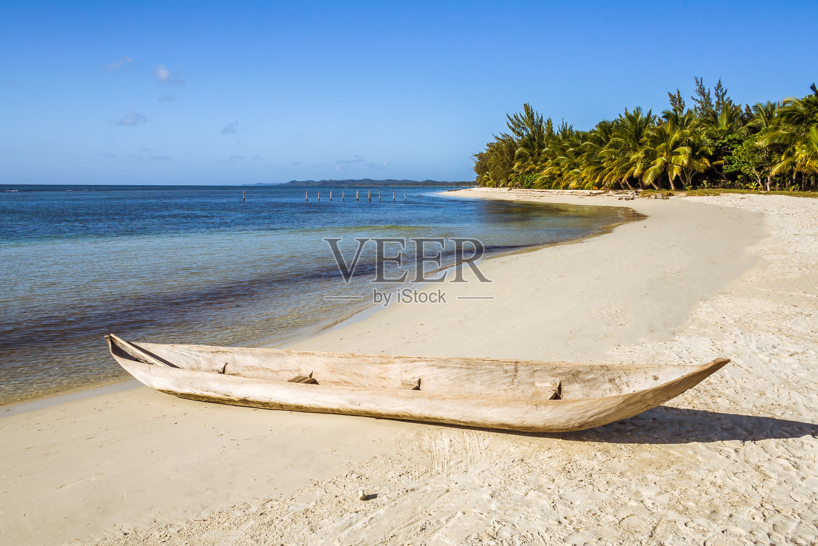 热带海滩上的木独木舟照片摄影图片