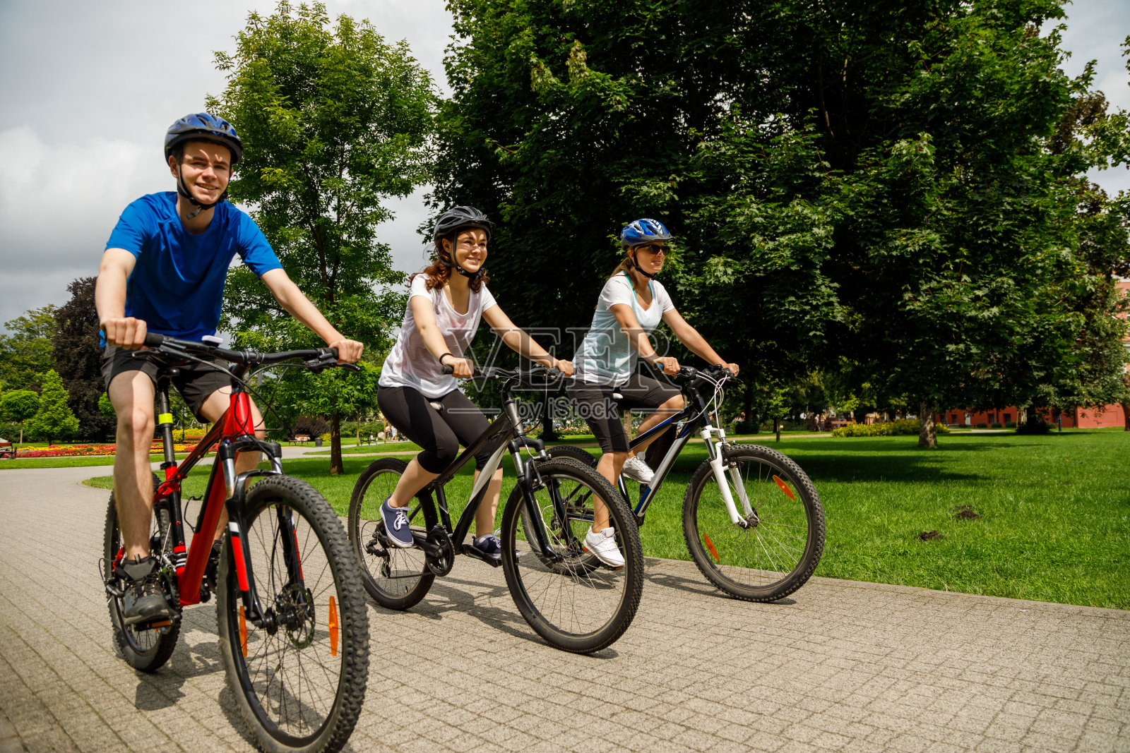 城市自行车——三个人在城市里骑自行车照片摄影图片