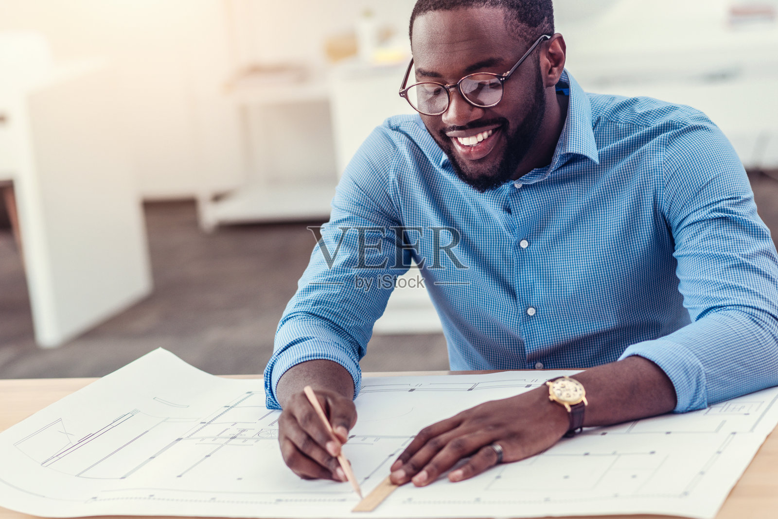 微笑的男工程师在桌子上绘制技术图纸照片摄影图片