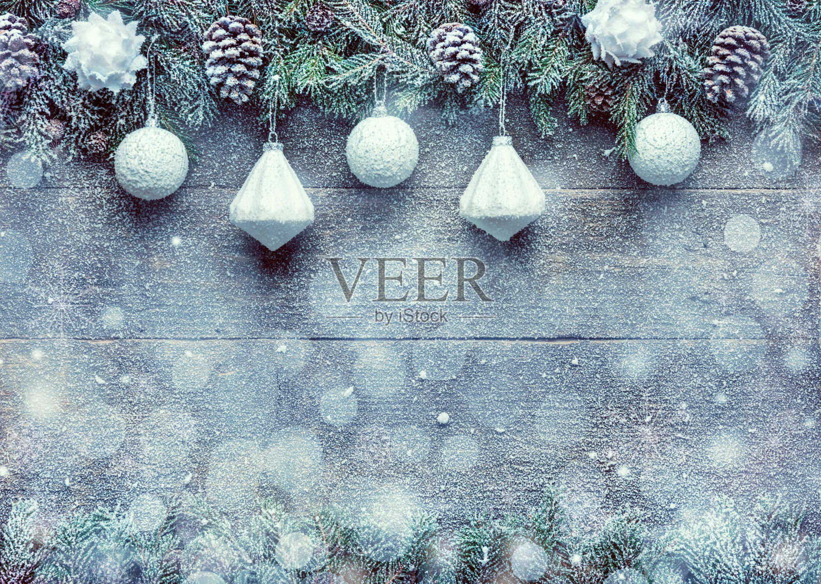 下雪的圣诞节背景，杉树枝与松果和圣诞装饰在木制的背景，节日横幅与拷贝空间照片摄影图片