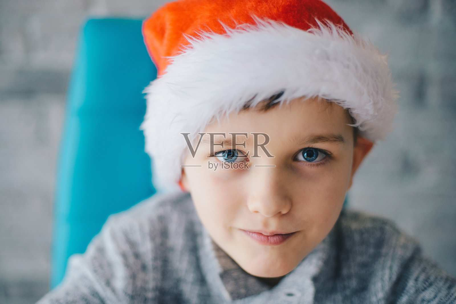 戴着圣诞老人帽的8岁男孩照片摄影图片