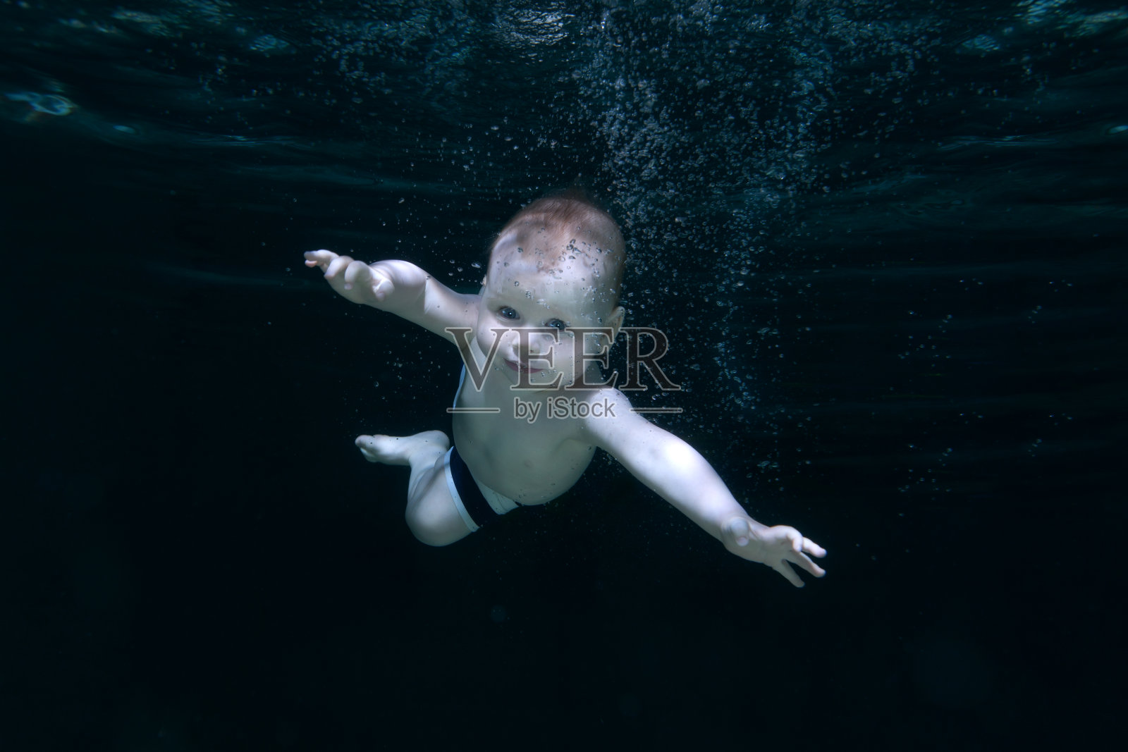 孩子在水里。照片摄影图片