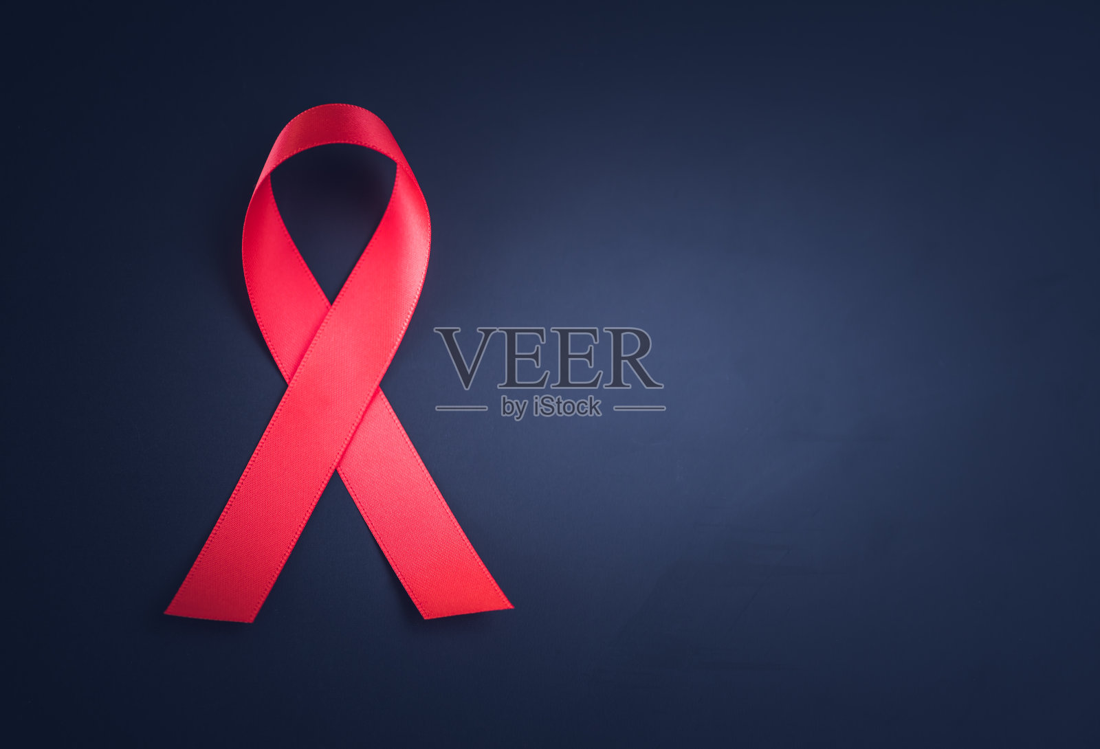 世界艾滋病日活动以黑色为背景的红丝带宣传。照片摄影图片