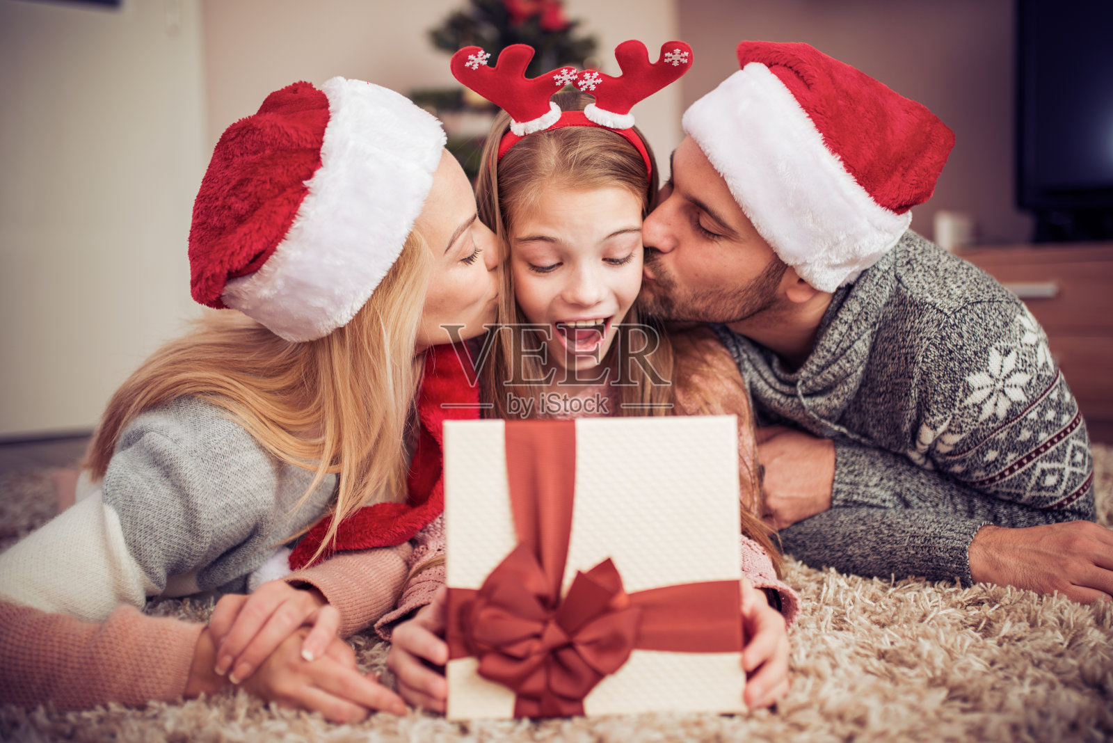 家人在圣诞树旁打开礼物照片摄影图片