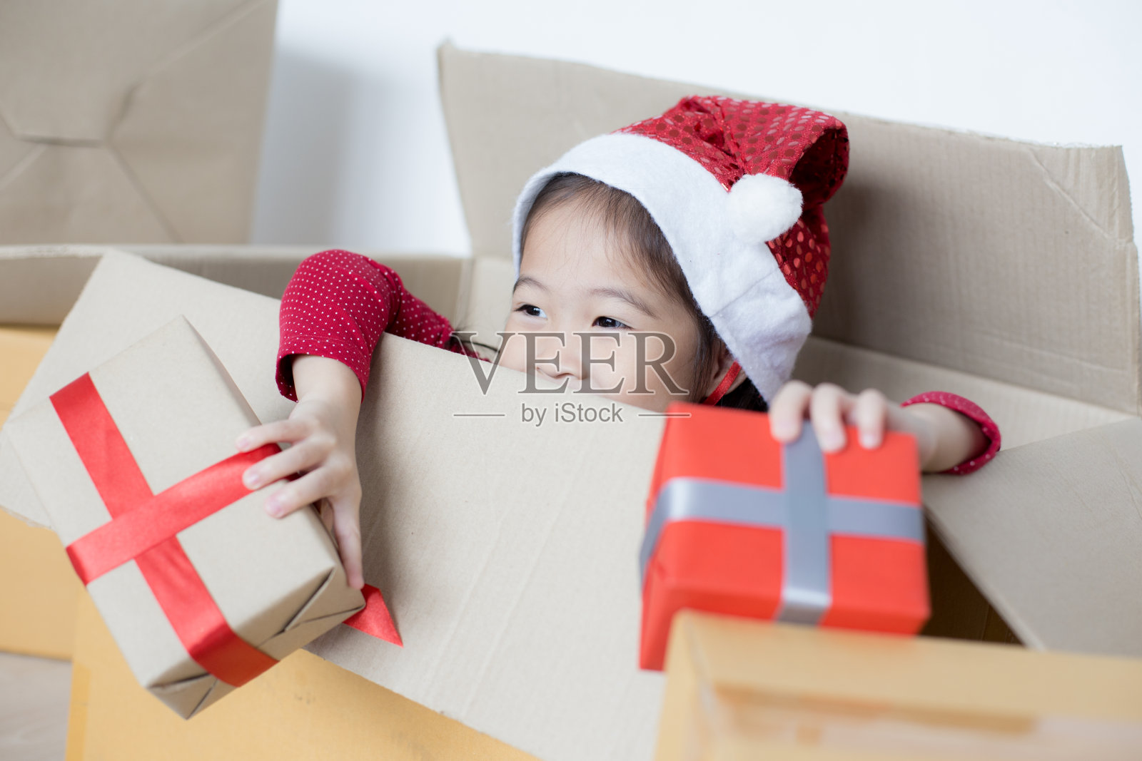 亚洲女孩拿着礼盒。孩子微笑着拿着盒子。照片摄影图片