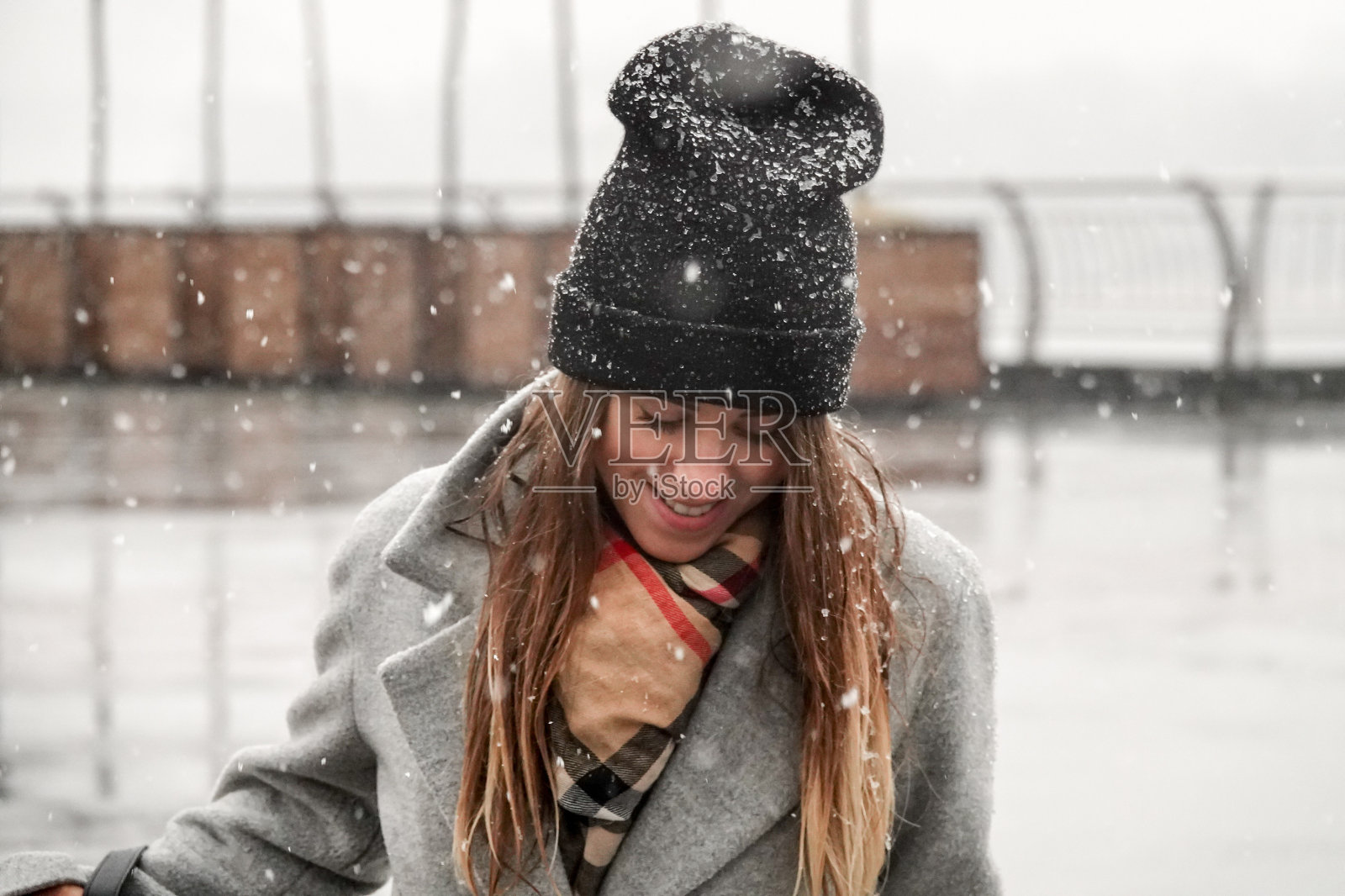 一个戴着帽子穿灰色外套的女孩的肖像。照片摄影图片