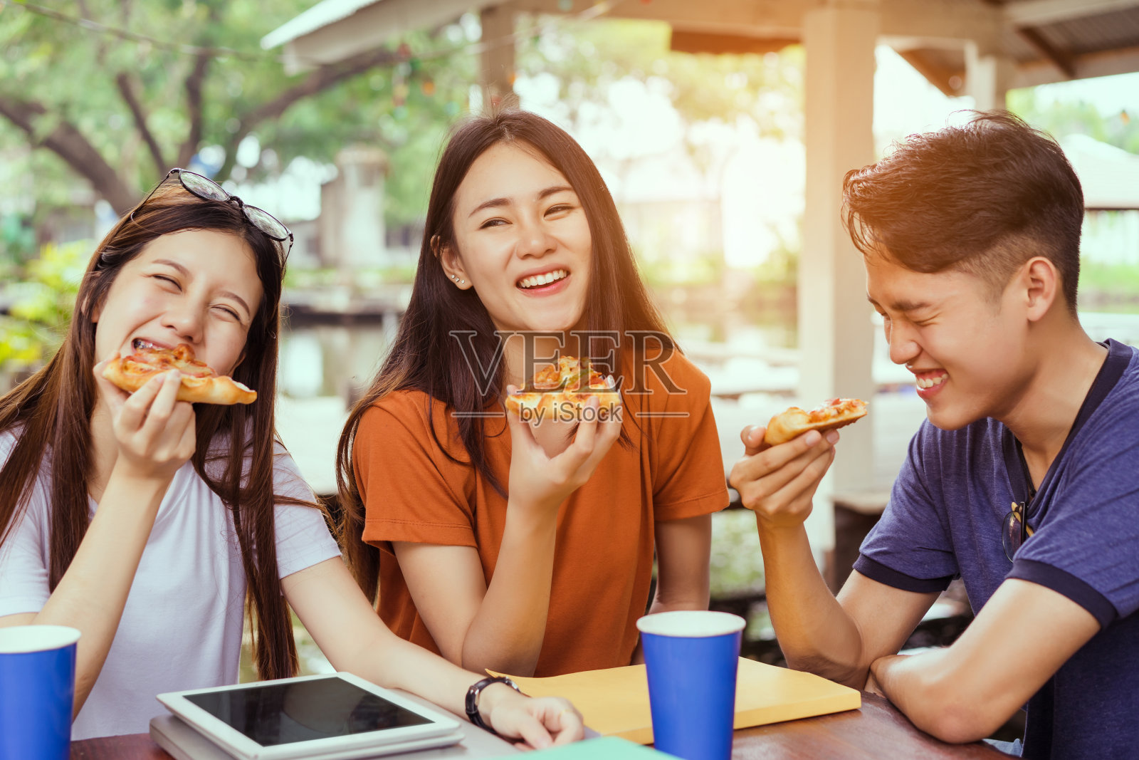 亚洲人在休息时间一起吃披萨，享受派对上的意大利奶酪片美味照片摄影图片