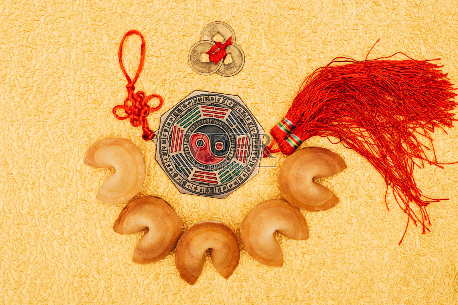 俯视图的中国护身符周围的幸运饼干在金色的表面，中国新年的概念照片摄影图片