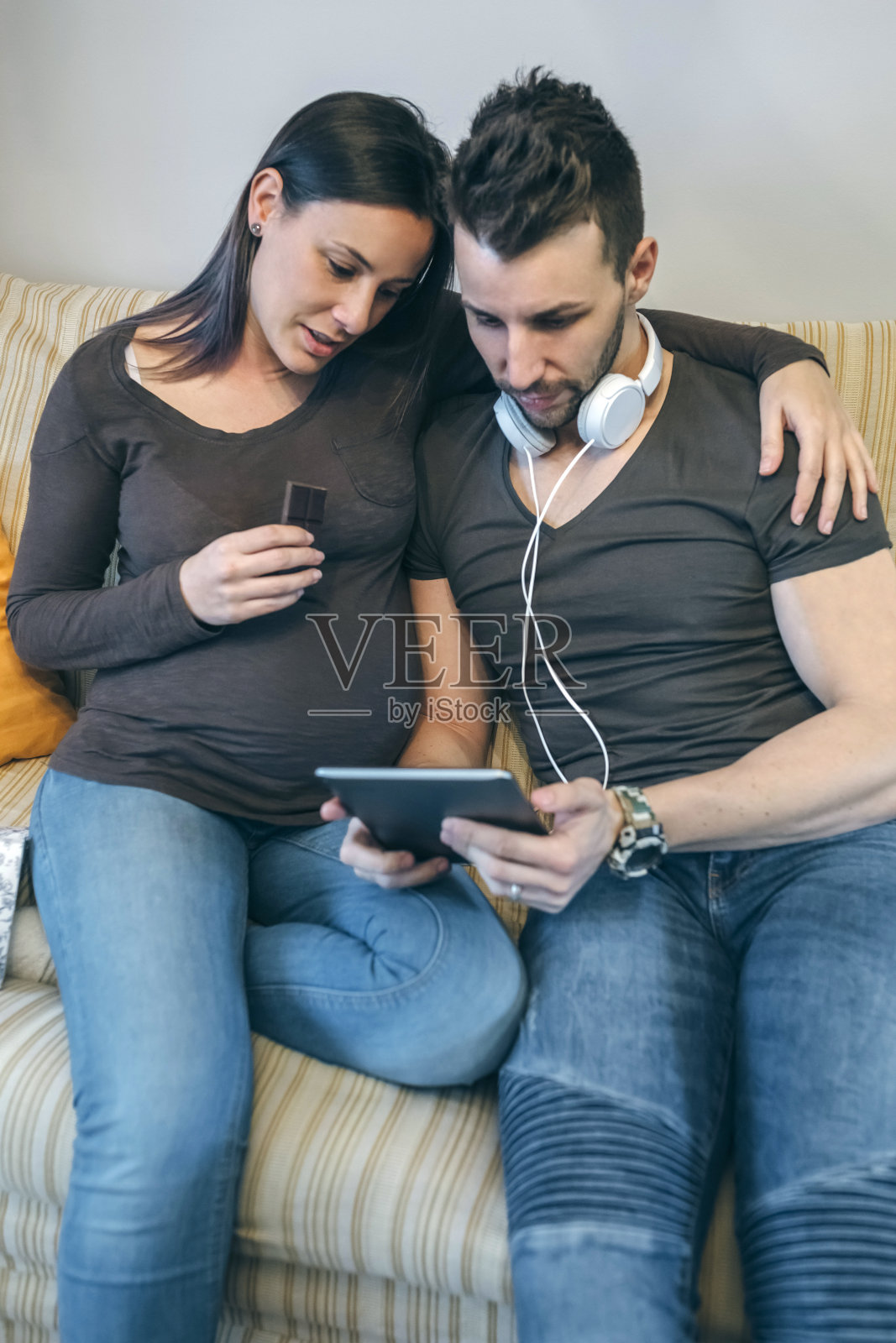 怀孕的时候，她的伴侣正在看平板电脑照片摄影图片