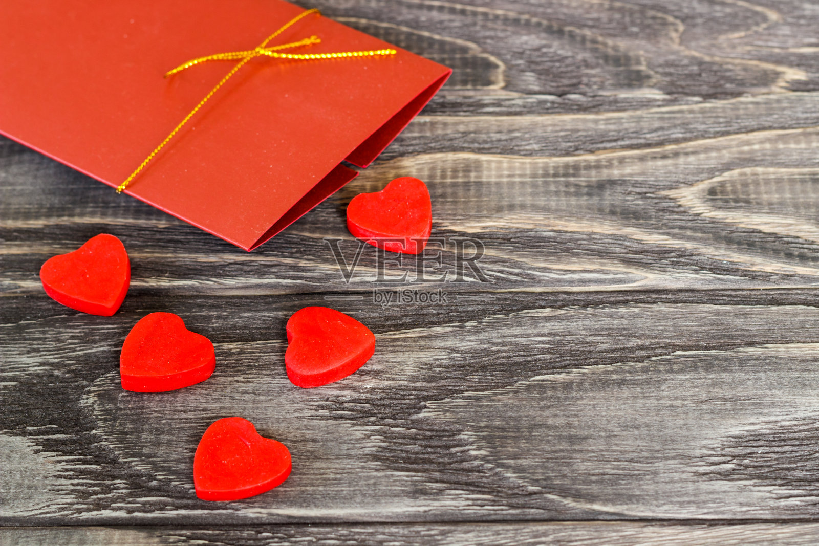 在深色的木制背景上有爱心和一个礼品信封。情人节的概念。照片摄影图片