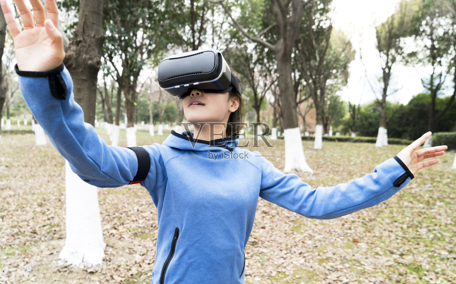 女性戴着VR眼镜在大自然中锻炼照片摄影图片