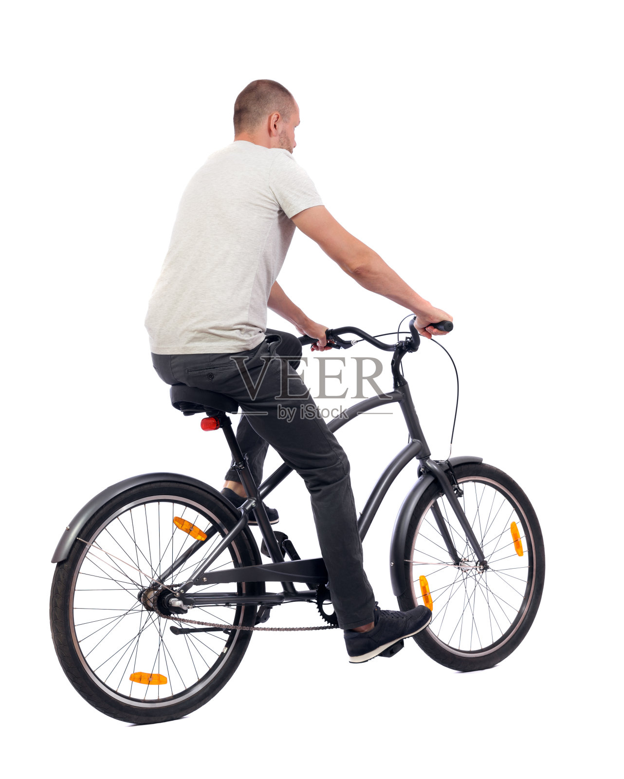 一个骑自行车的男人的后视图。照片摄影图片