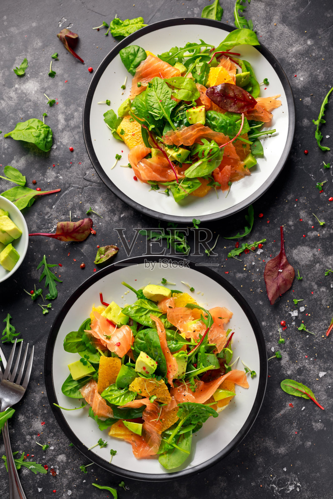 新鲜的三文鱼沙拉配鳄梨，橙和绿色蔬菜照片摄影图片