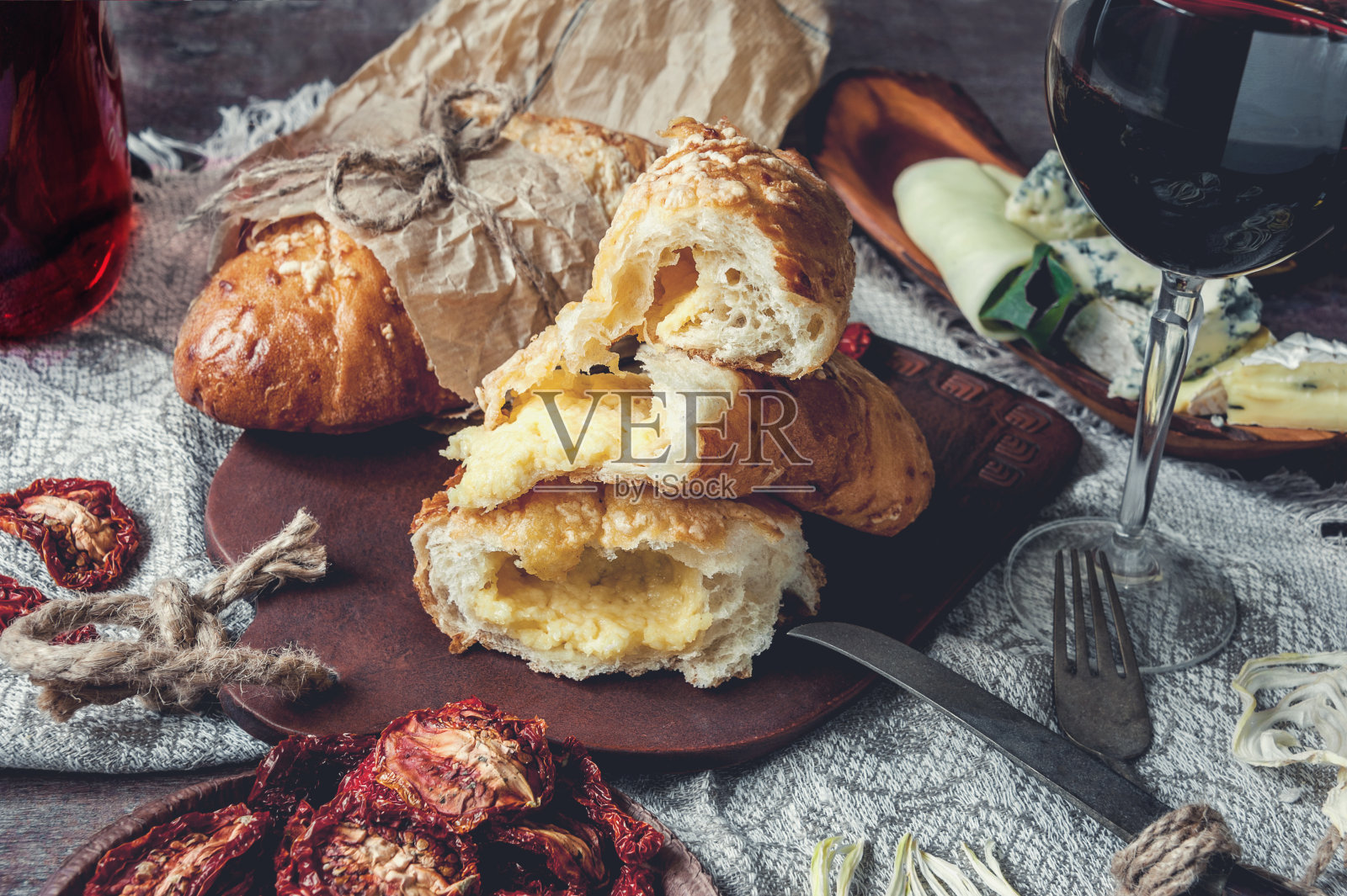 一杯干红葡萄酒、意大利佛卡夏面包、奶酪、橄榄油和番茄干。有选择性的重点。照片摄影图片