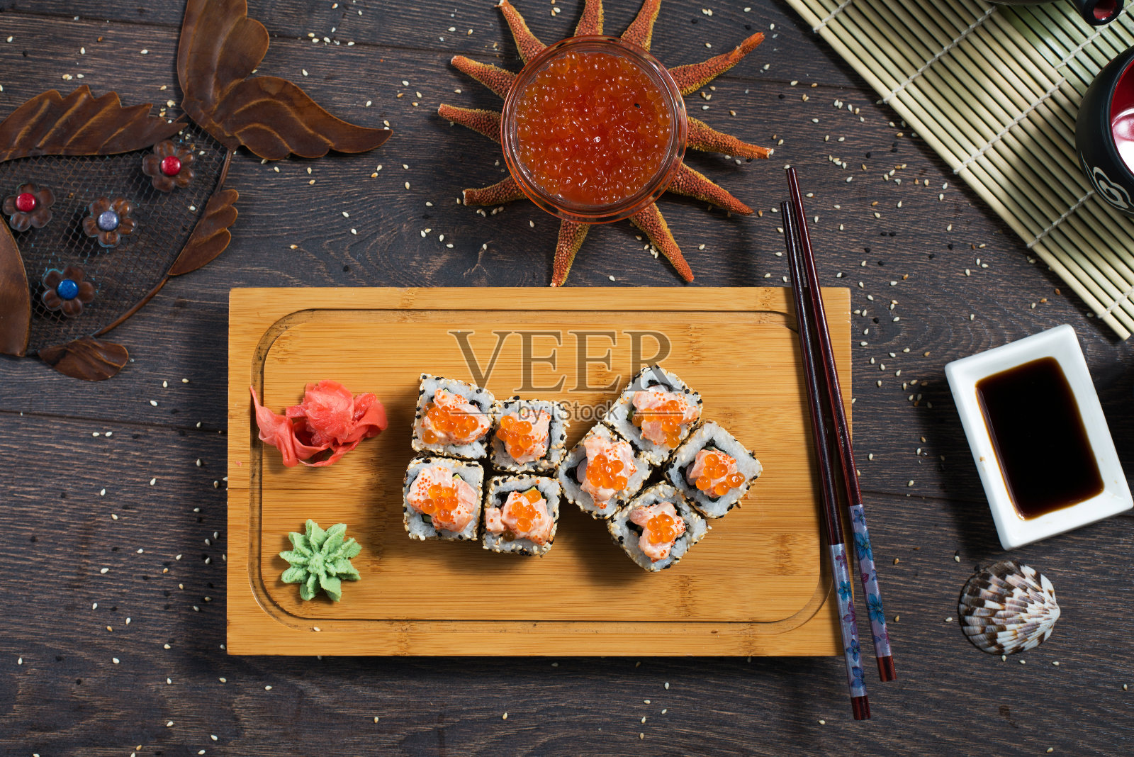 寿司卷和鱼子酱放在黑色的木桌上。日本的食物。照片摄影图片