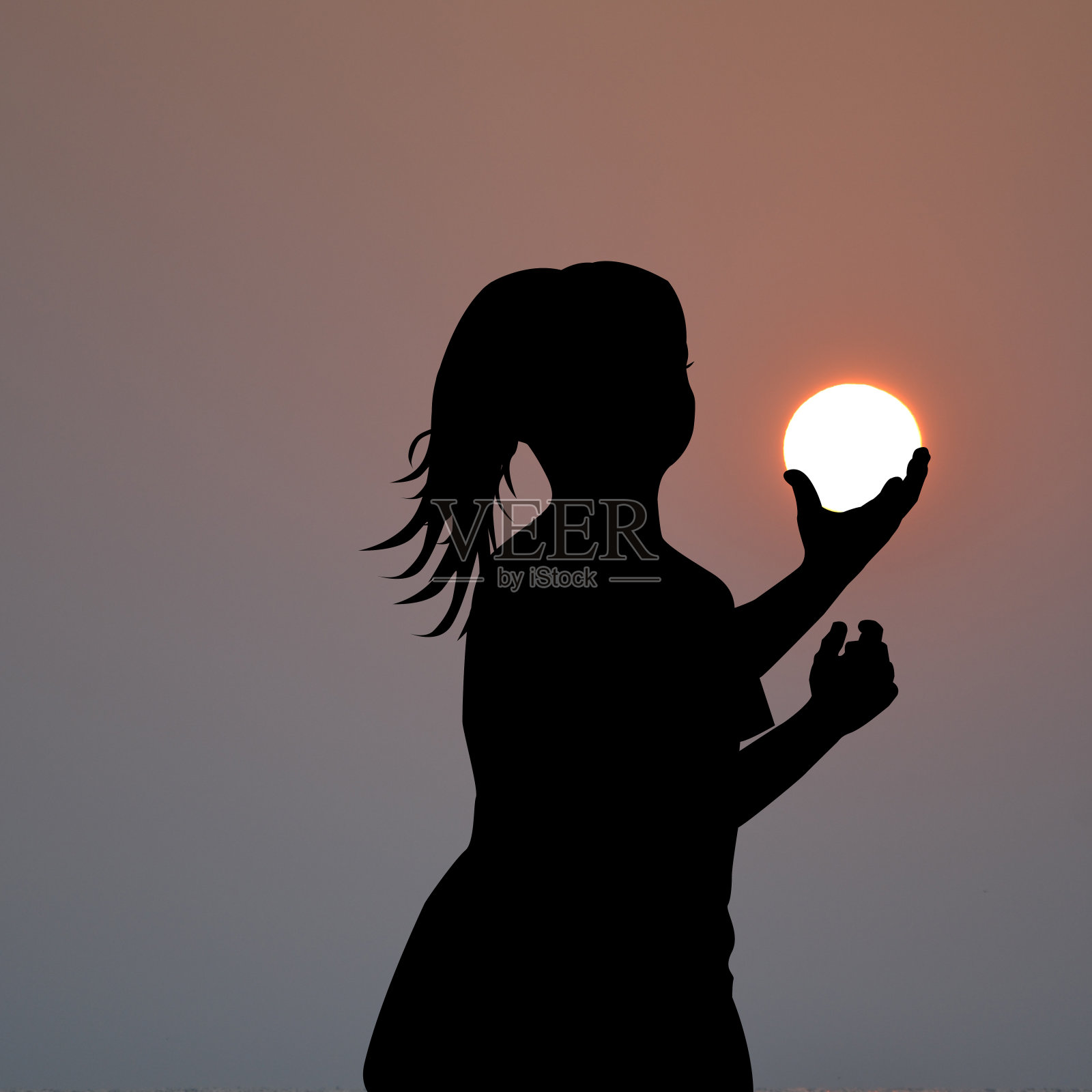 女孩的剪影，手中握着太阳照片摄影图片
