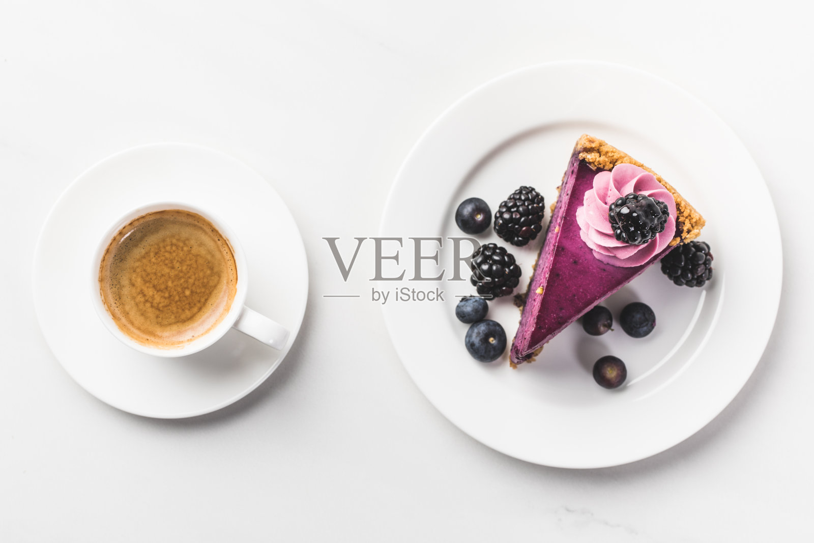 顶视图的一块蛋糕与浆果和一杯咖啡孤立在白色的桌面上照片摄影图片