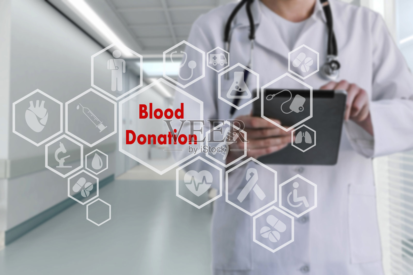 触摸屏上献血图标的背景模糊了医生在医院吃药的画面。创新治疗、服务、健康数据分析。献血拯救生命的医疗保健理念。6月14日世界献血日。照片摄影图片