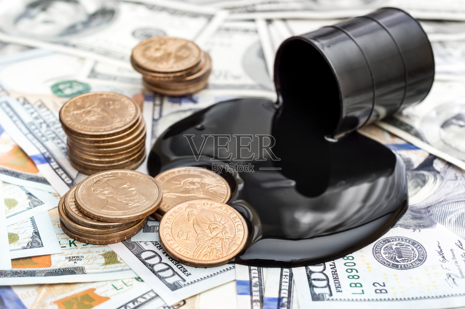 原油从桶中溢出，金币以美元为背景。经营理念。照片摄影图片