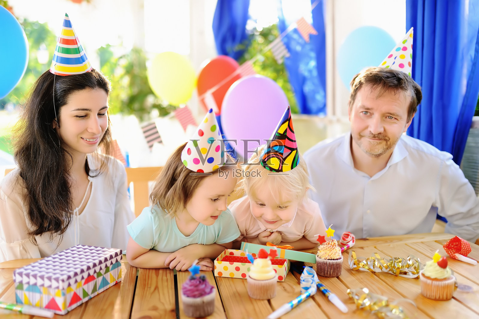 小朋友和他们的父母用五颜六色的装饰和蛋糕来庆祝生日派对照片摄影图片
