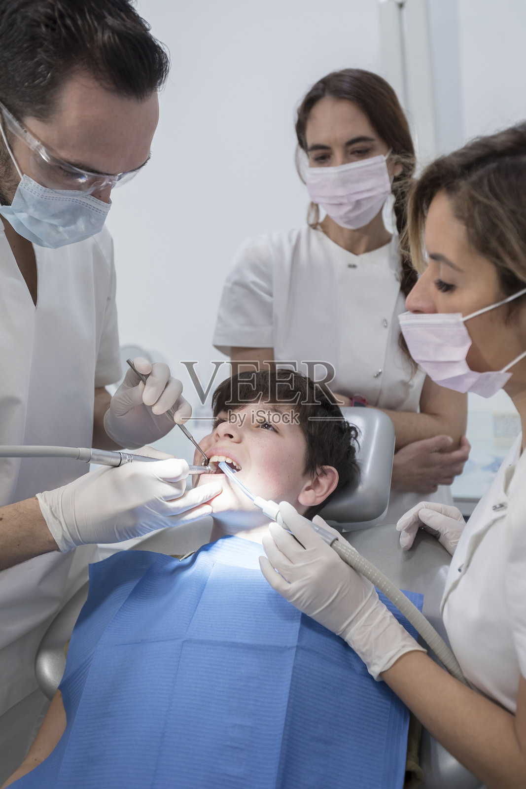 牙医在诊所检查小男孩的牙齿照片摄影图片