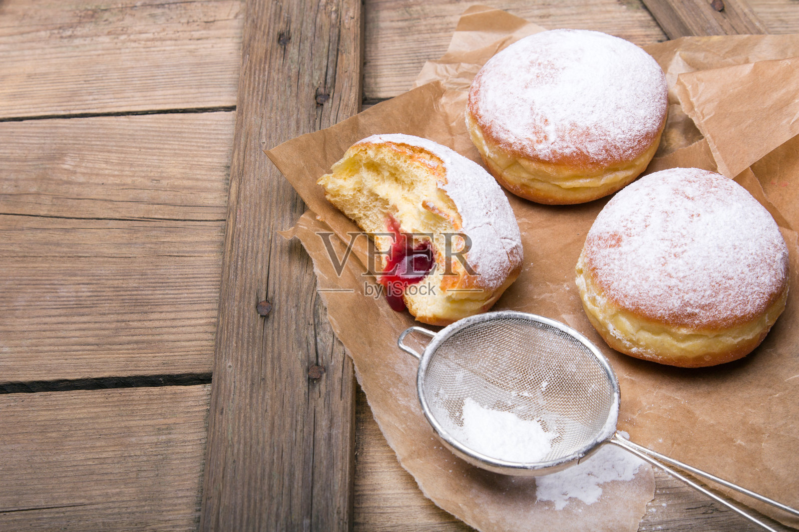 传统的波兰甜甜圈木制背景。美味的果酱甜甜圈。照片摄影图片