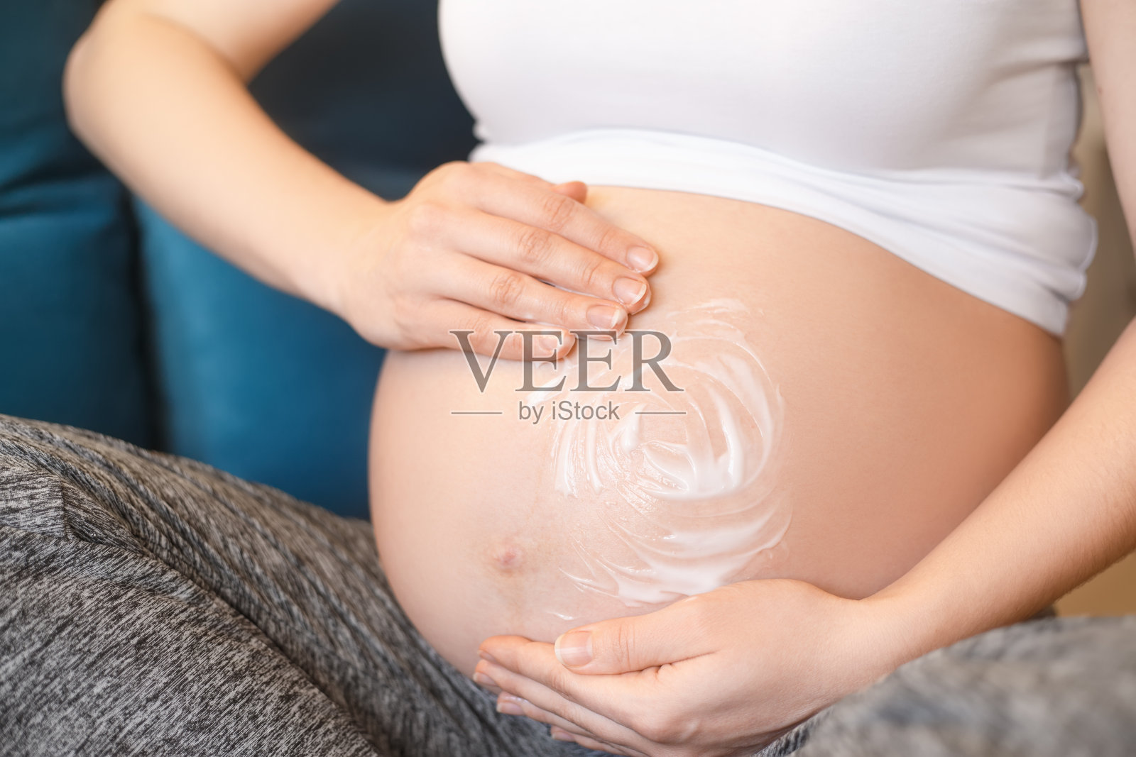 孕妇在肚子上涂霜照片摄影图片