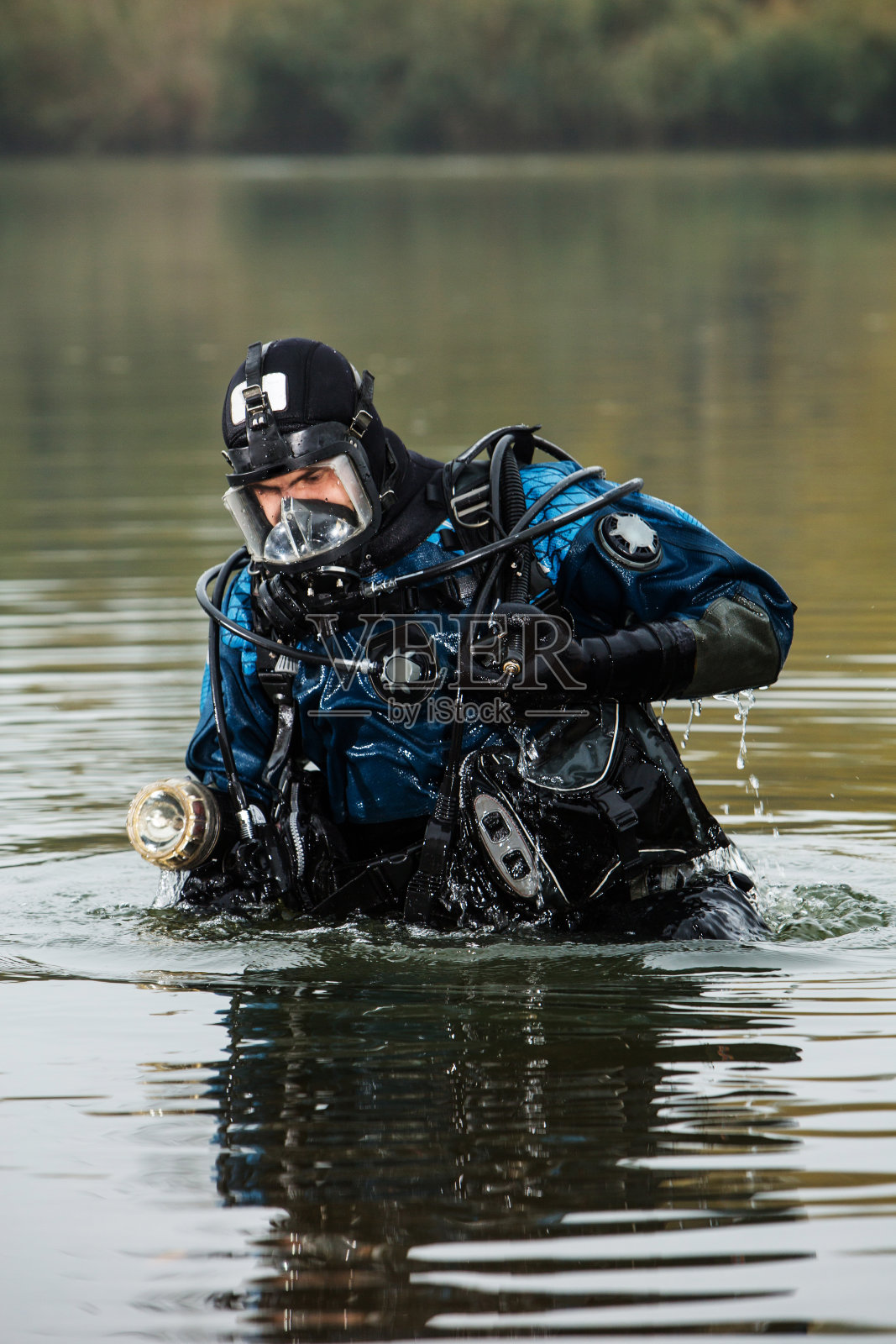一位男性潜水者从水下爬回海岸照片摄影图片