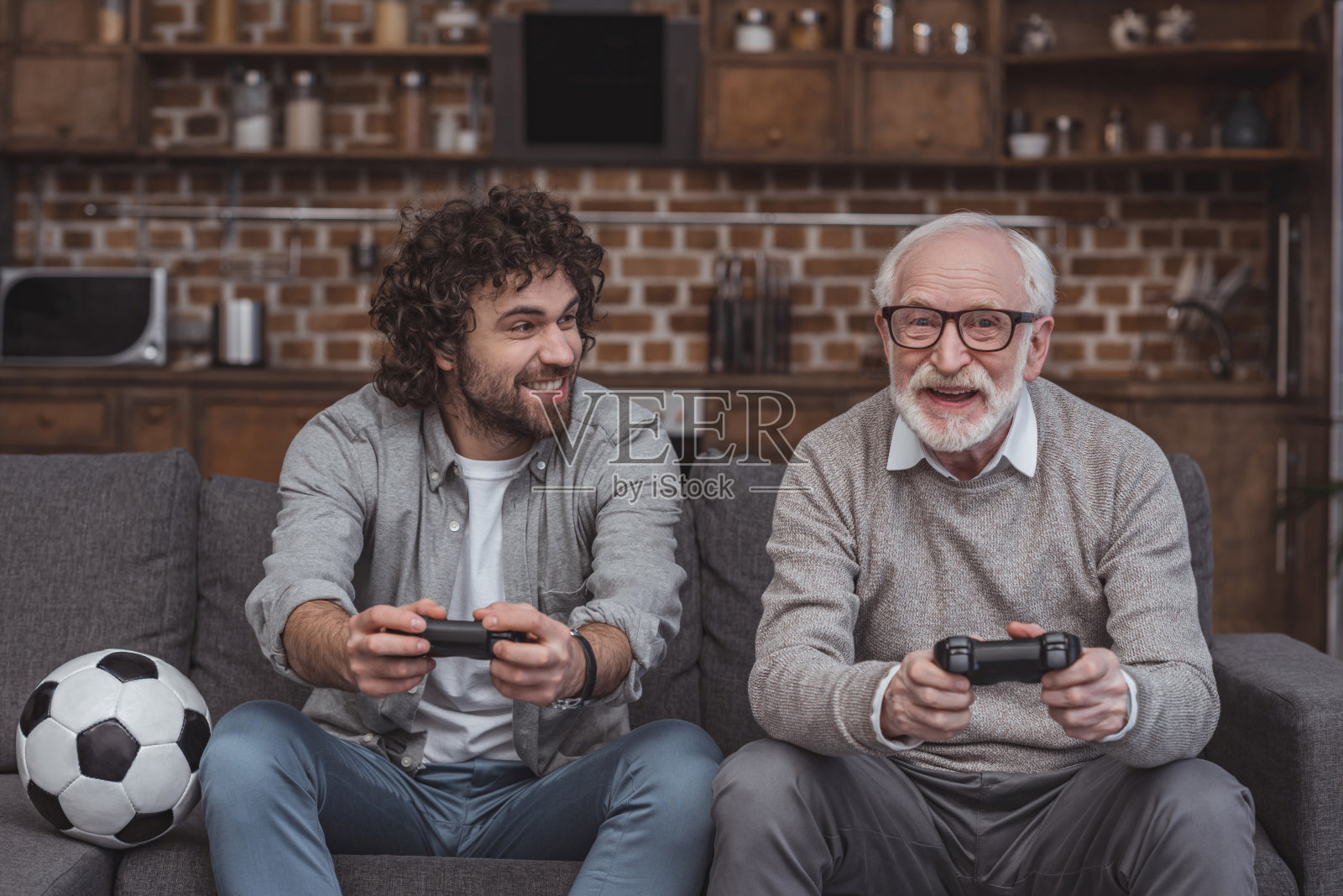 快乐的成年儿子和年长的父亲一起在家里玩电子游戏照片摄影图片