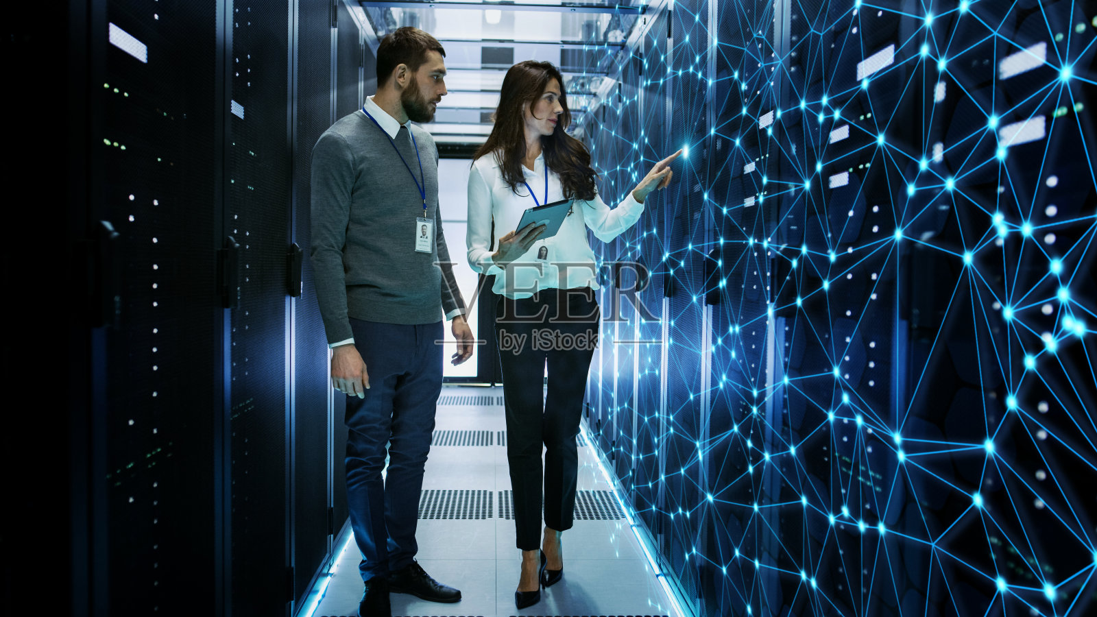 女性和男性IT工程师在工作数据中心/服务器室讨论技术细节与互联网连接可视化。照片摄影图片