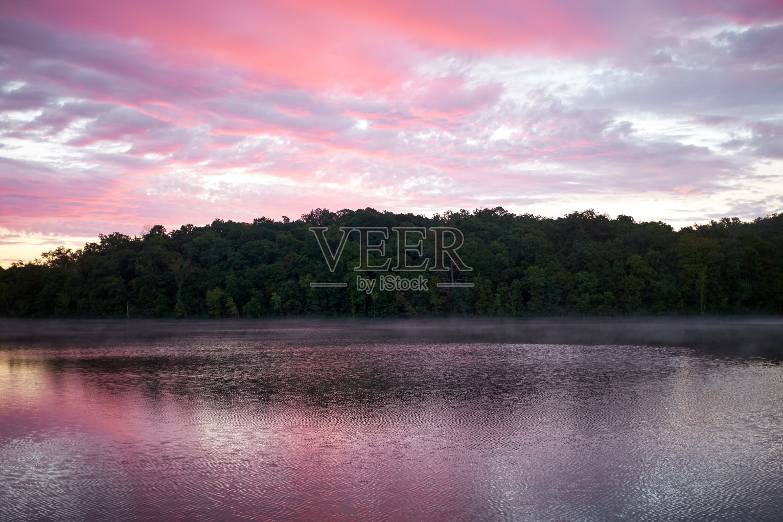 壮观的粉红色日落倒映在湖中照片摄影图片
