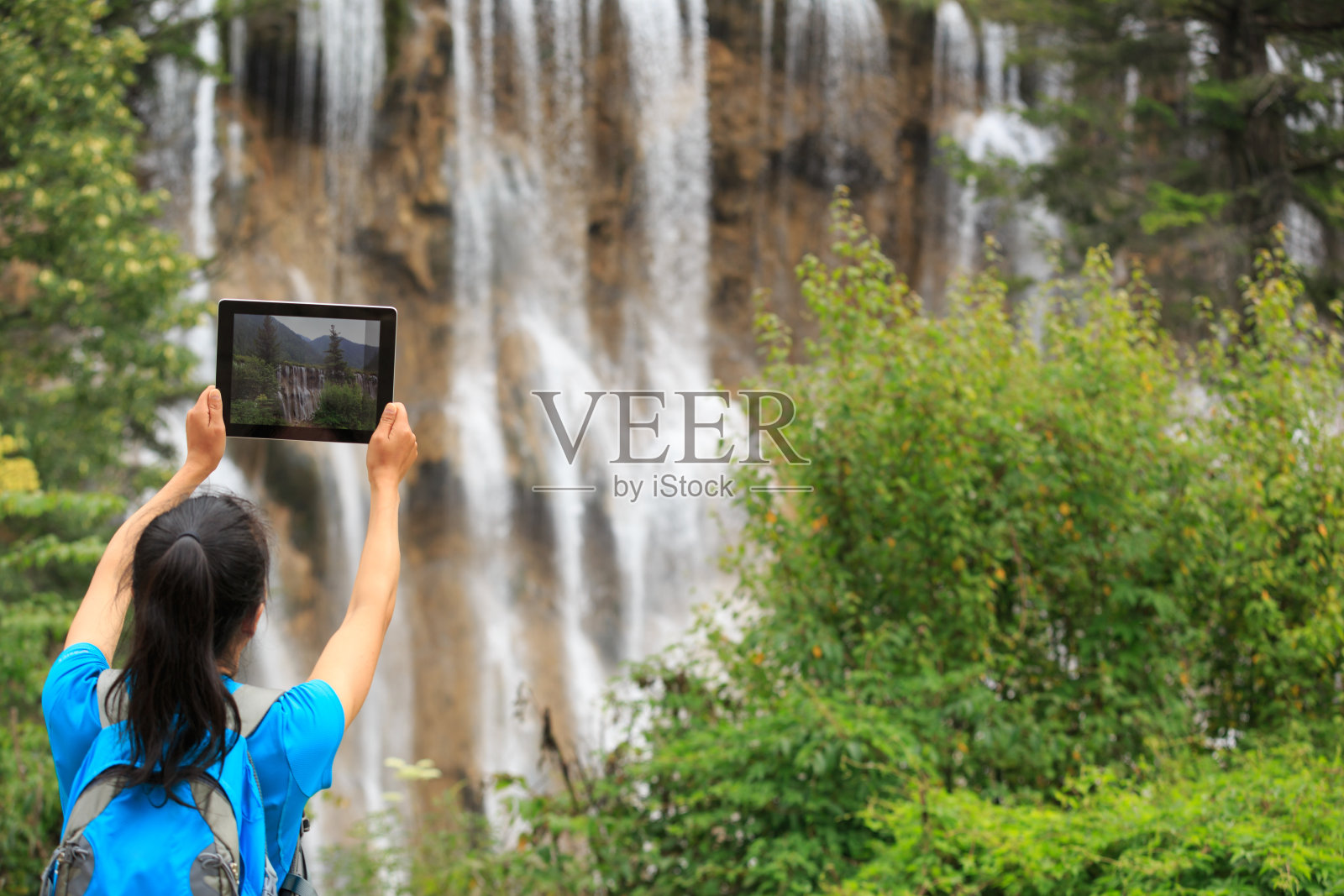 女游客用数码平板电脑拍照照片摄影图片
