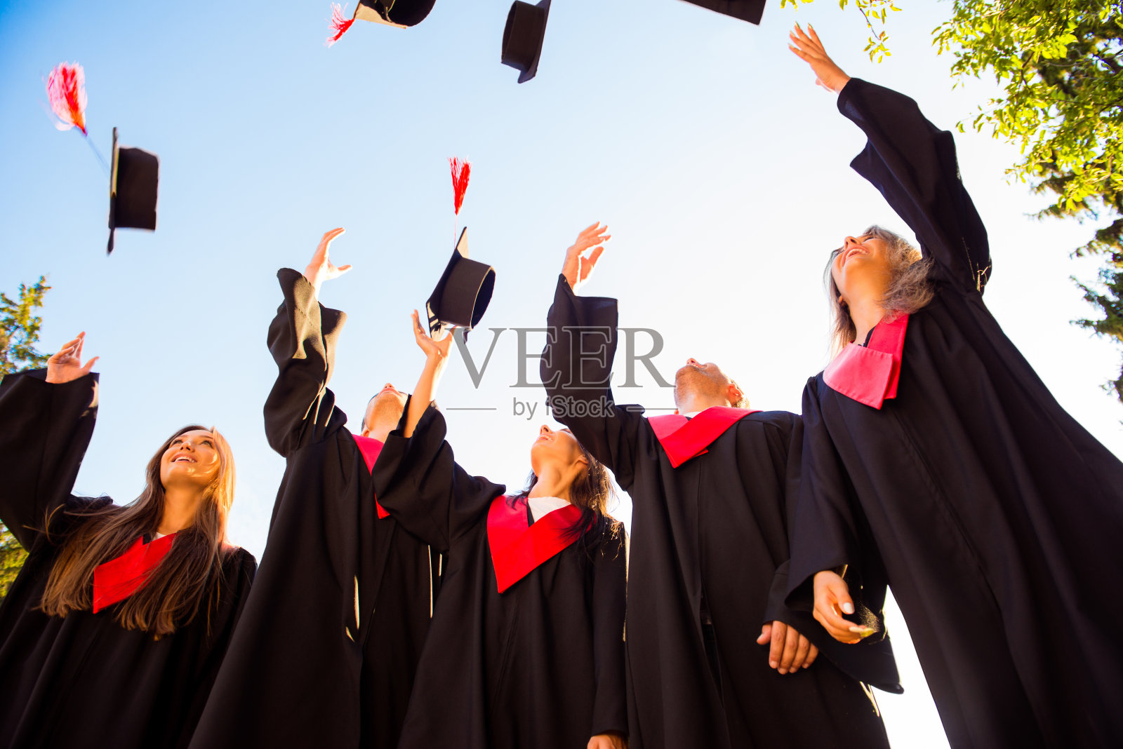 一群快乐的毕业青年学生向空中抛帽子照片摄影图片