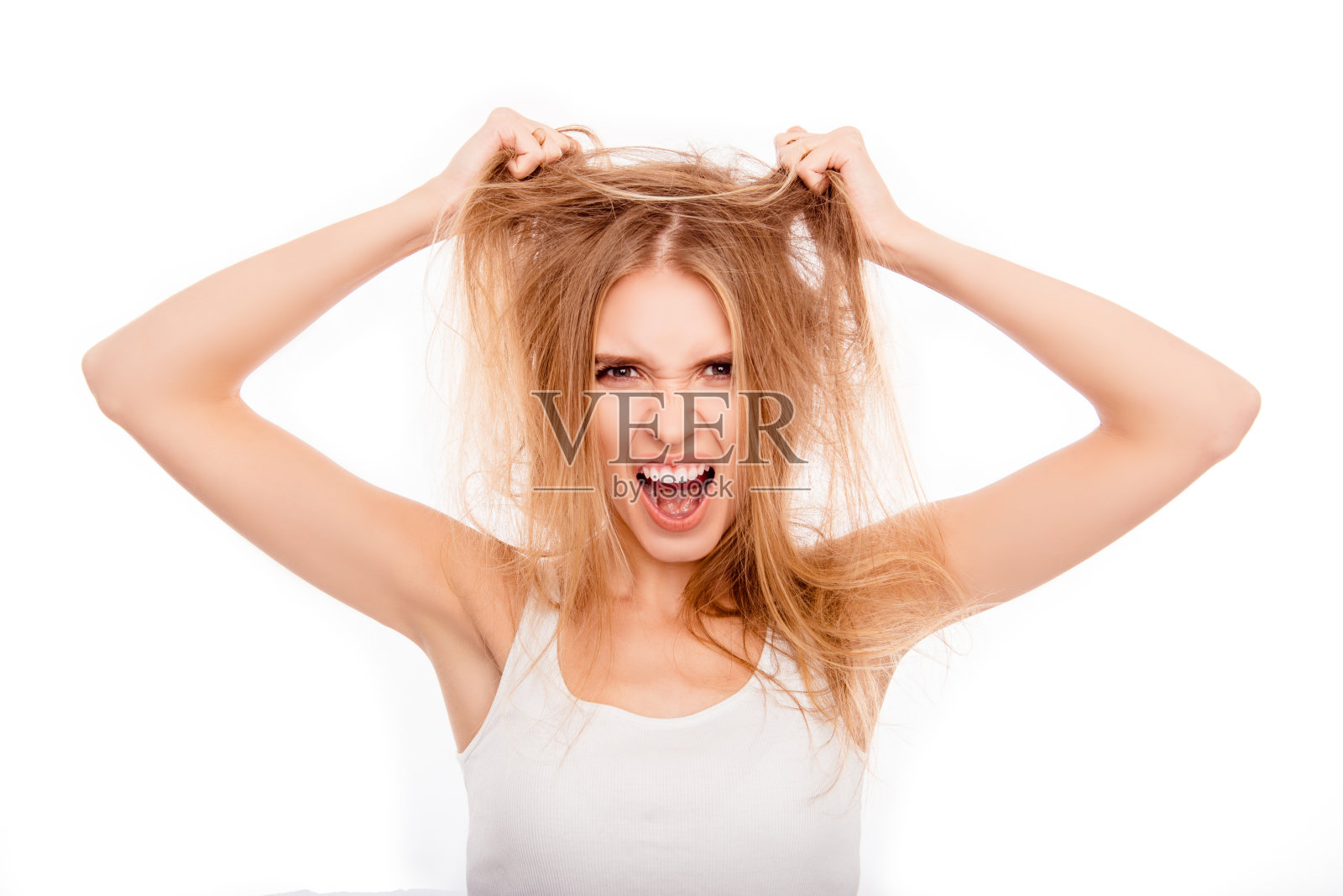 沮丧的金发女郎抱着她受损的头发大喊大叫照片摄影图片