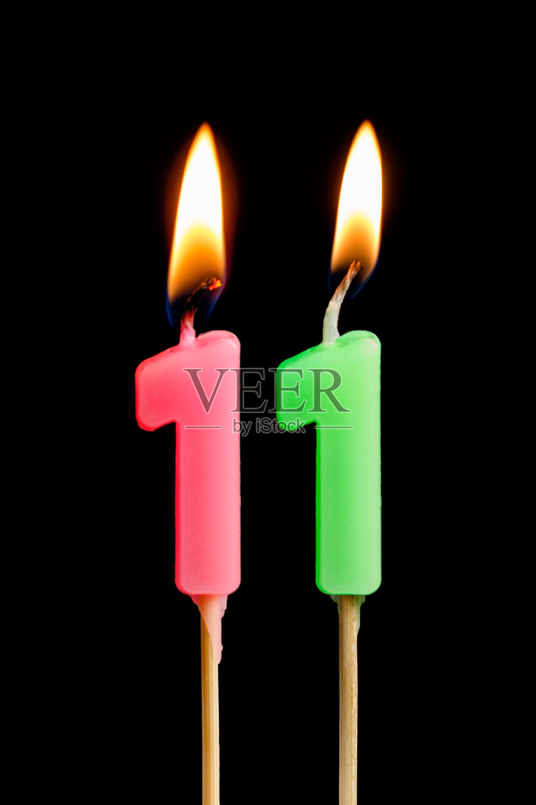 燃烧蜡烛的形式11十一个数字(数字，日期)的蛋糕孤立在黑色的背景。庆祝生日、周年纪念、重要日期、节日、餐桌摆设的概念照片摄影图片