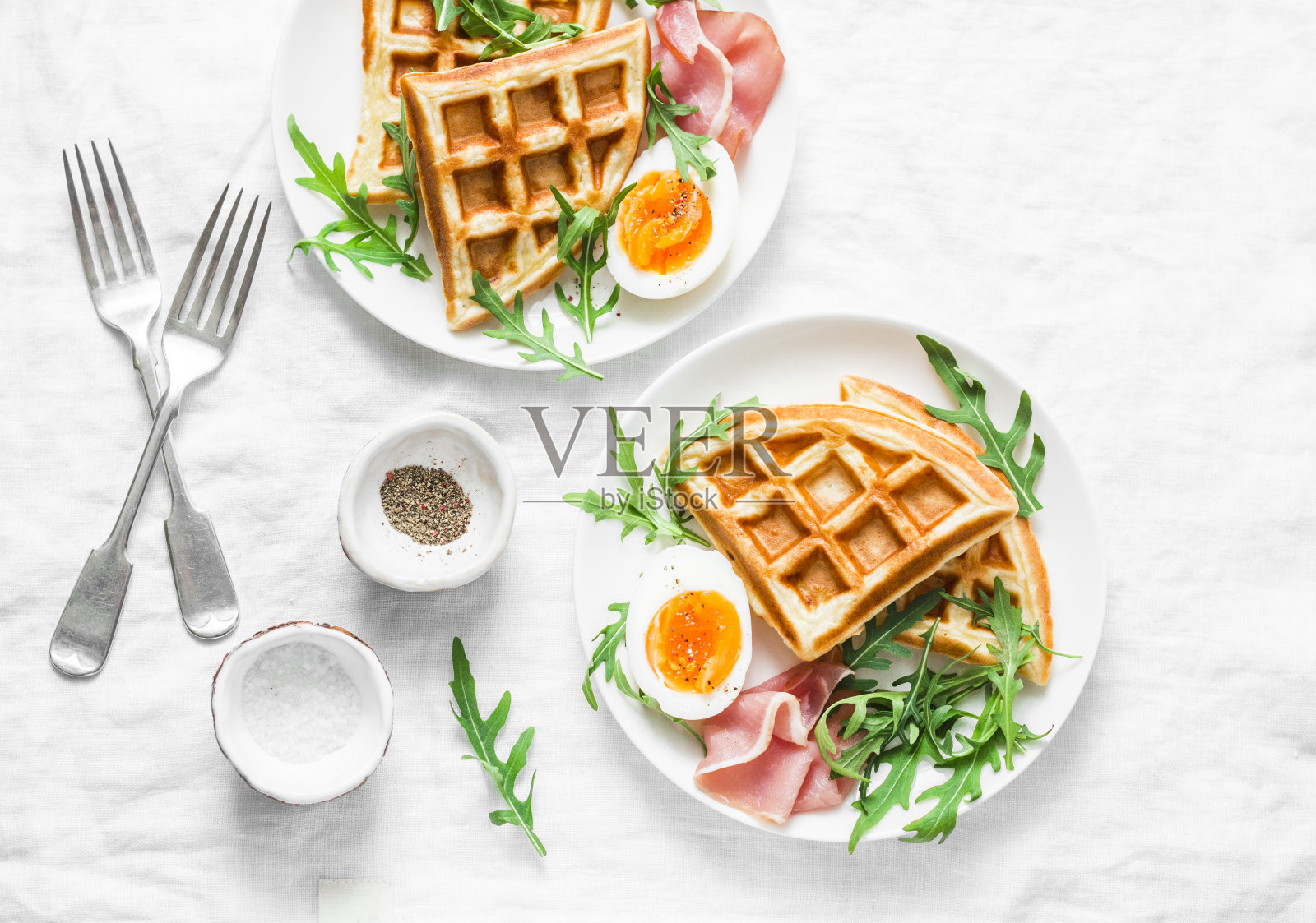 早餐有土豆、美味的华夫饼、煮鸡蛋、火腿和芝麻菜在光的背景，俯视图。开胃菜,点心,早午餐。美味健康的食品理念。平躺照片摄影图片