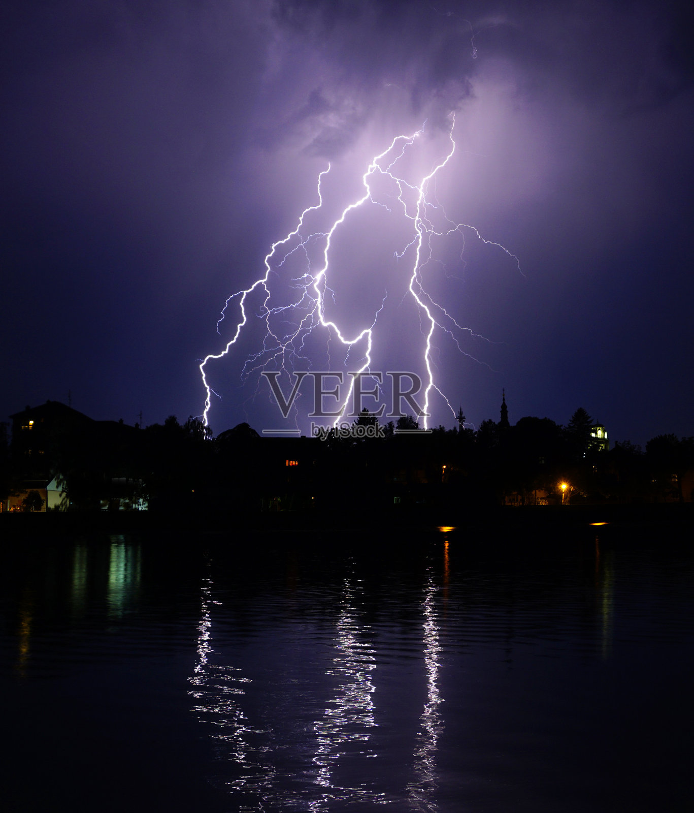 夏天暴风雨时镇上上空的闪电照片摄影图片