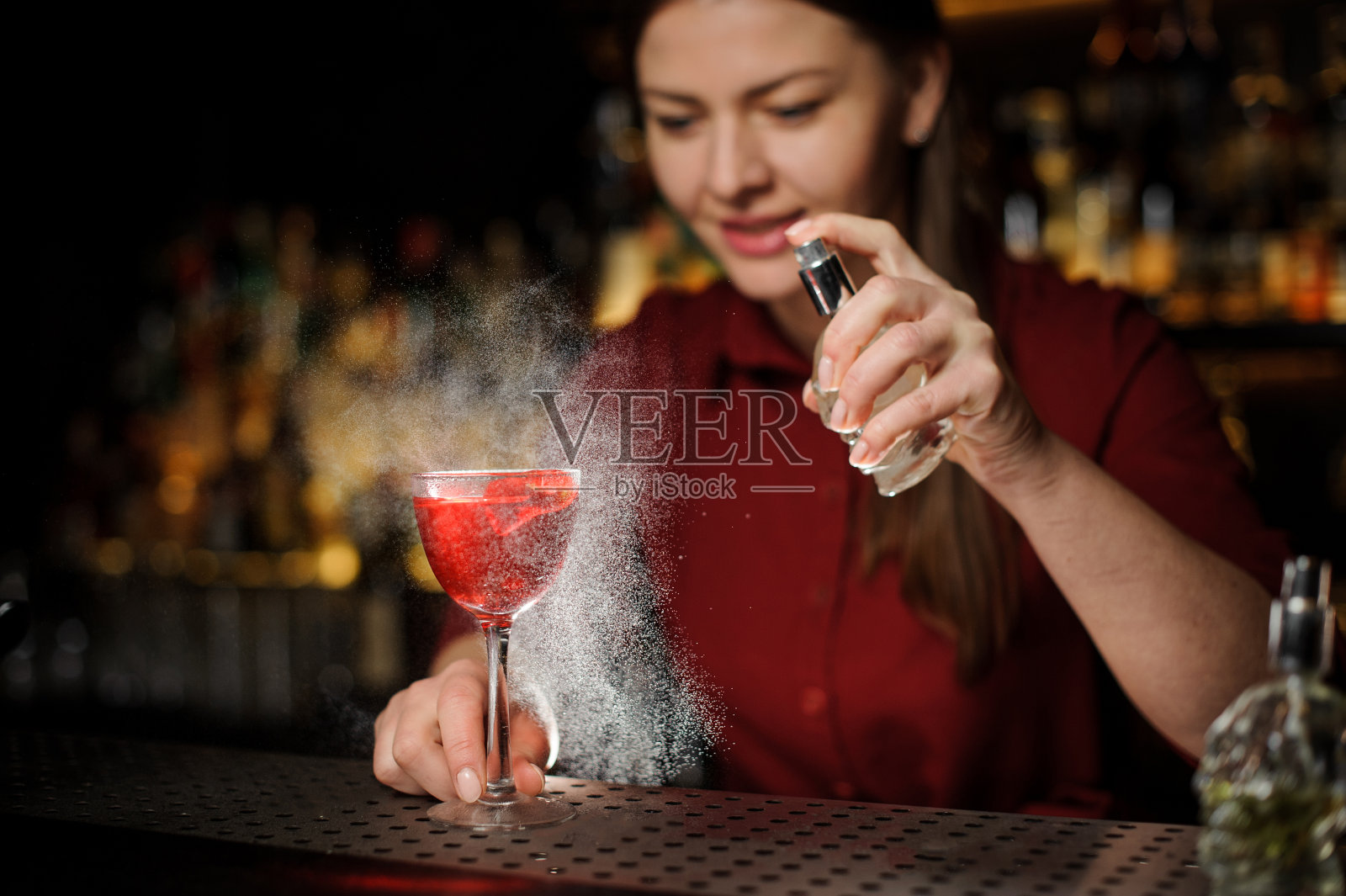 酒保女孩在酒精鸡尾酒中加入了泥煤威士忌照片摄影图片