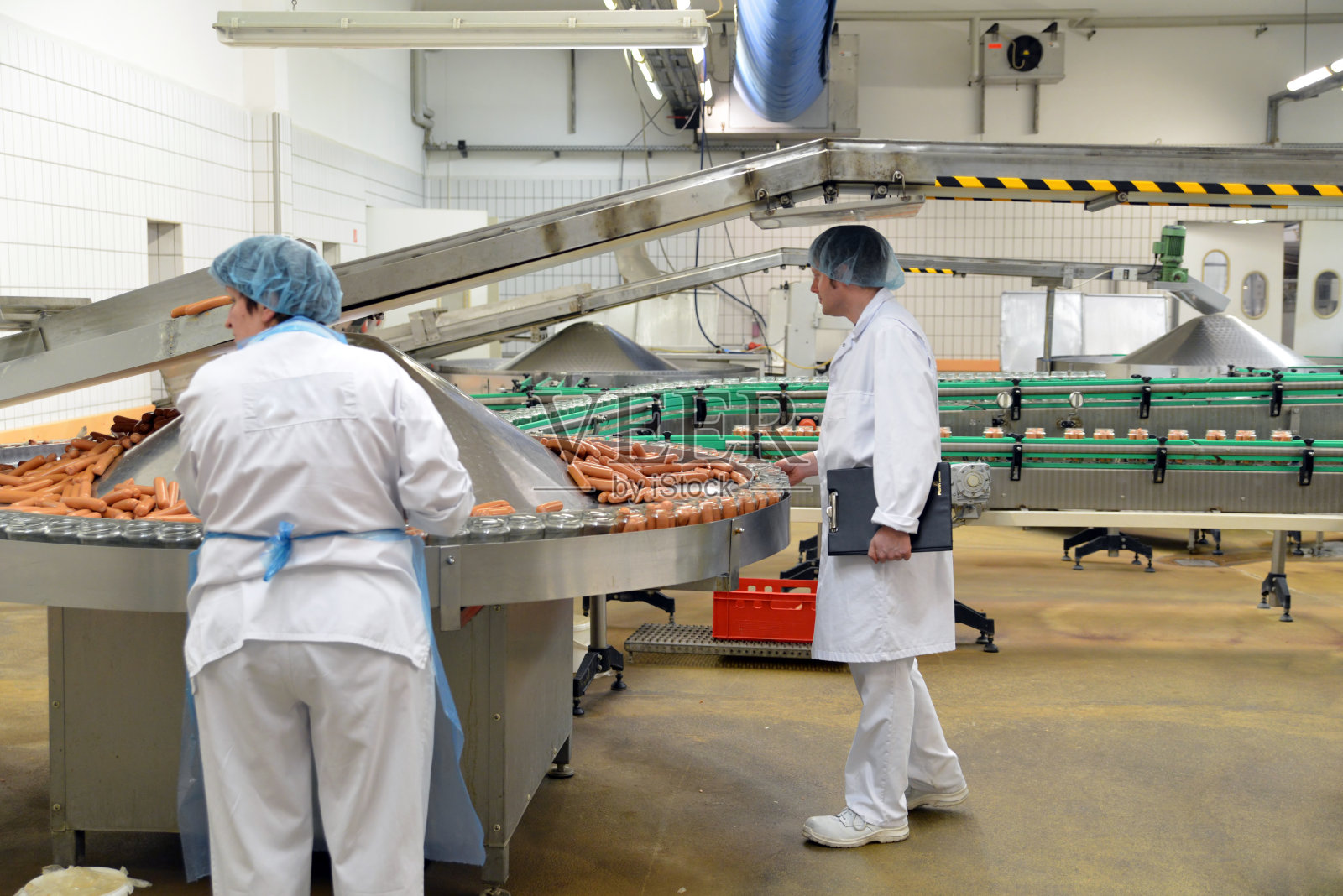 食品工业的工作场所——生产香肠的屠宰厂——妇女在装配线上工作照片摄影图片